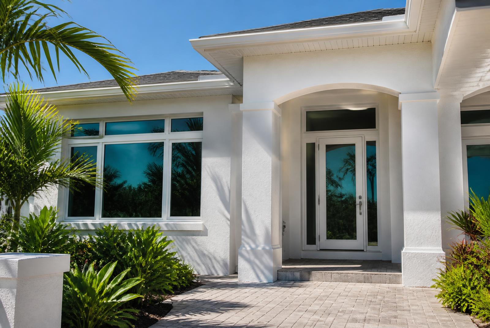 Impact-resistant windows and a modern glass entry door installed on a Florida home